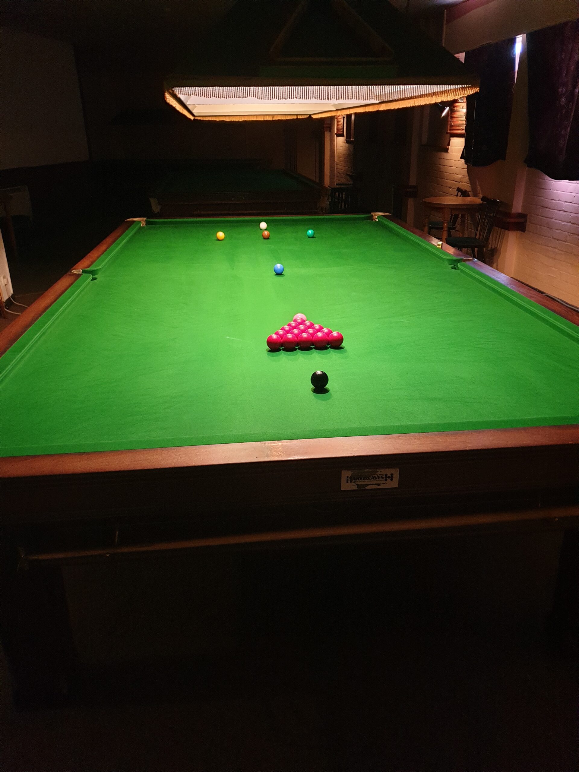 A snooker table as seen from the bottom cushion before the break-off shot